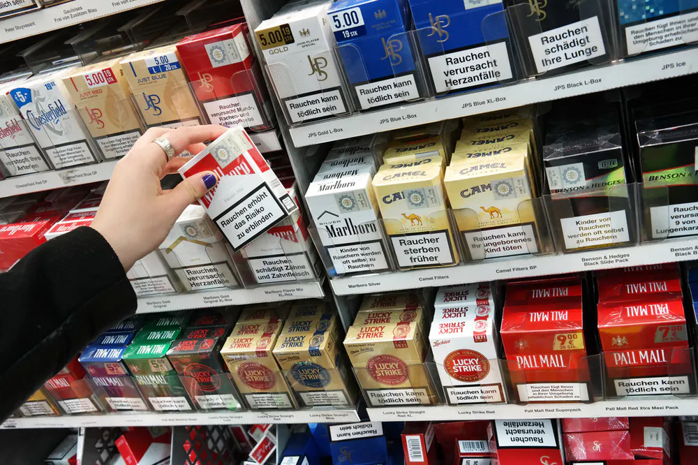 Hand reaching for cigarette packs in store
