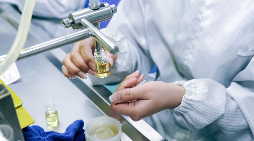 Scena w nowoczesnym laboratorium: naukowiec w fartuchu bada próbki liquidów pod mikroskopem lub przy użyciu zaawansowanego sprzętu analitycznego, z e-papierosem w tle.