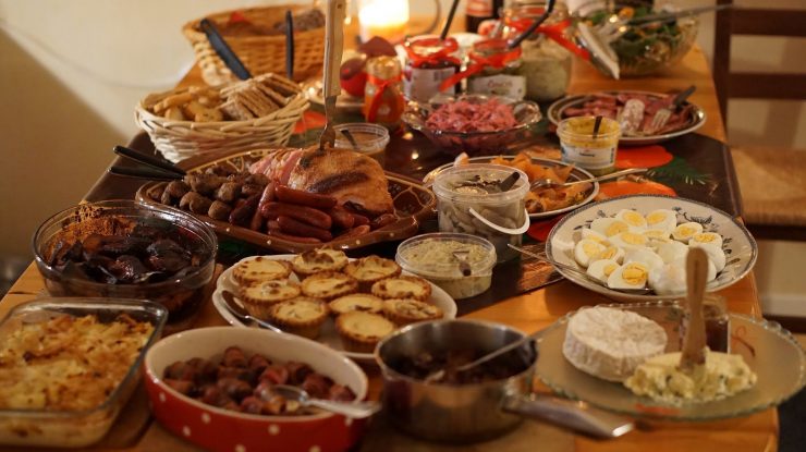 Stół szwedzki z obfitością kolorowych i różnorodnych potraw, wyraźnie kontrastujący z małą miską ziemniaków, symbolizując porównanie smaków