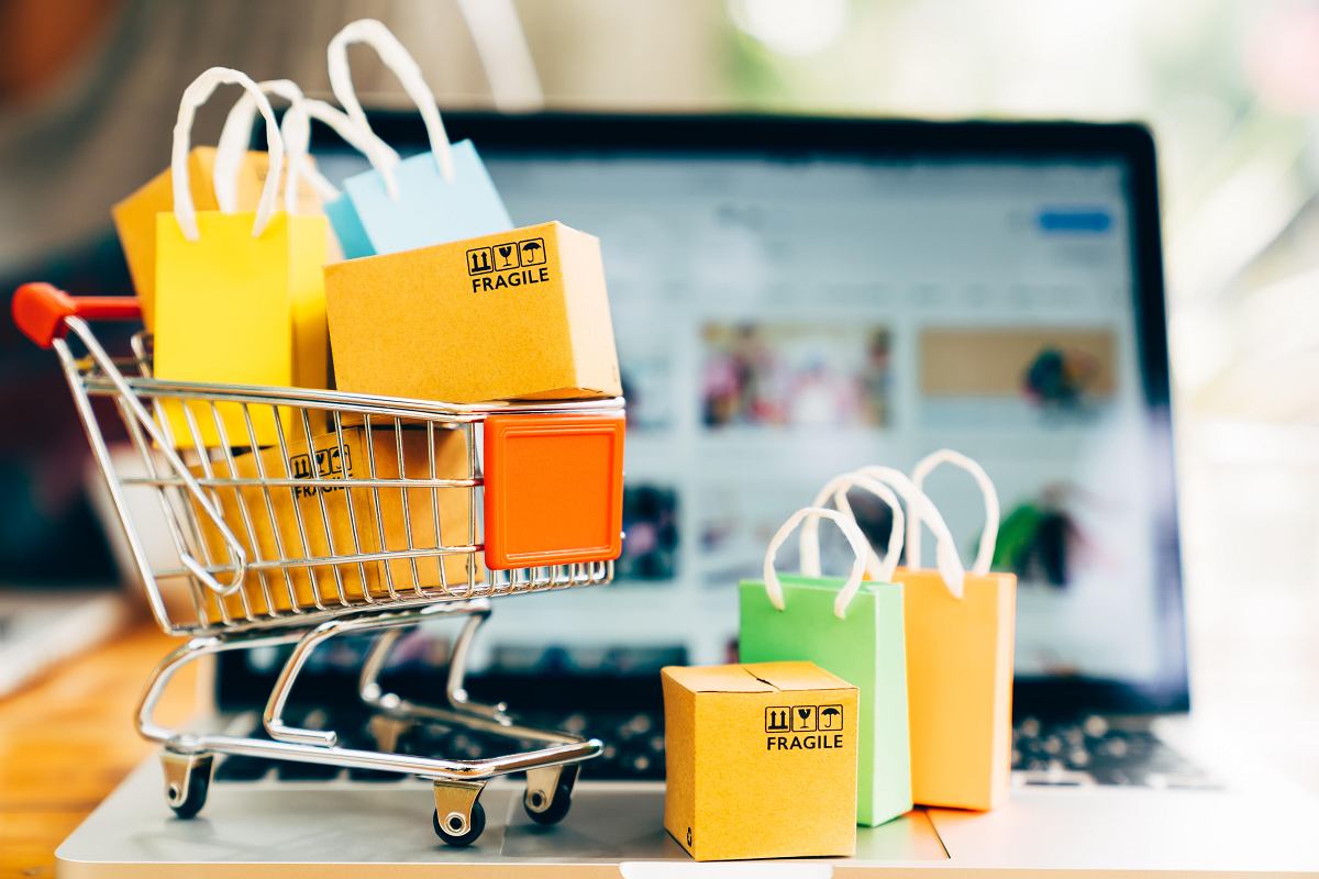 Porównanie zakupów online i w sklepie stacjonarnym z ikonami laptopa i budynku sklepu.