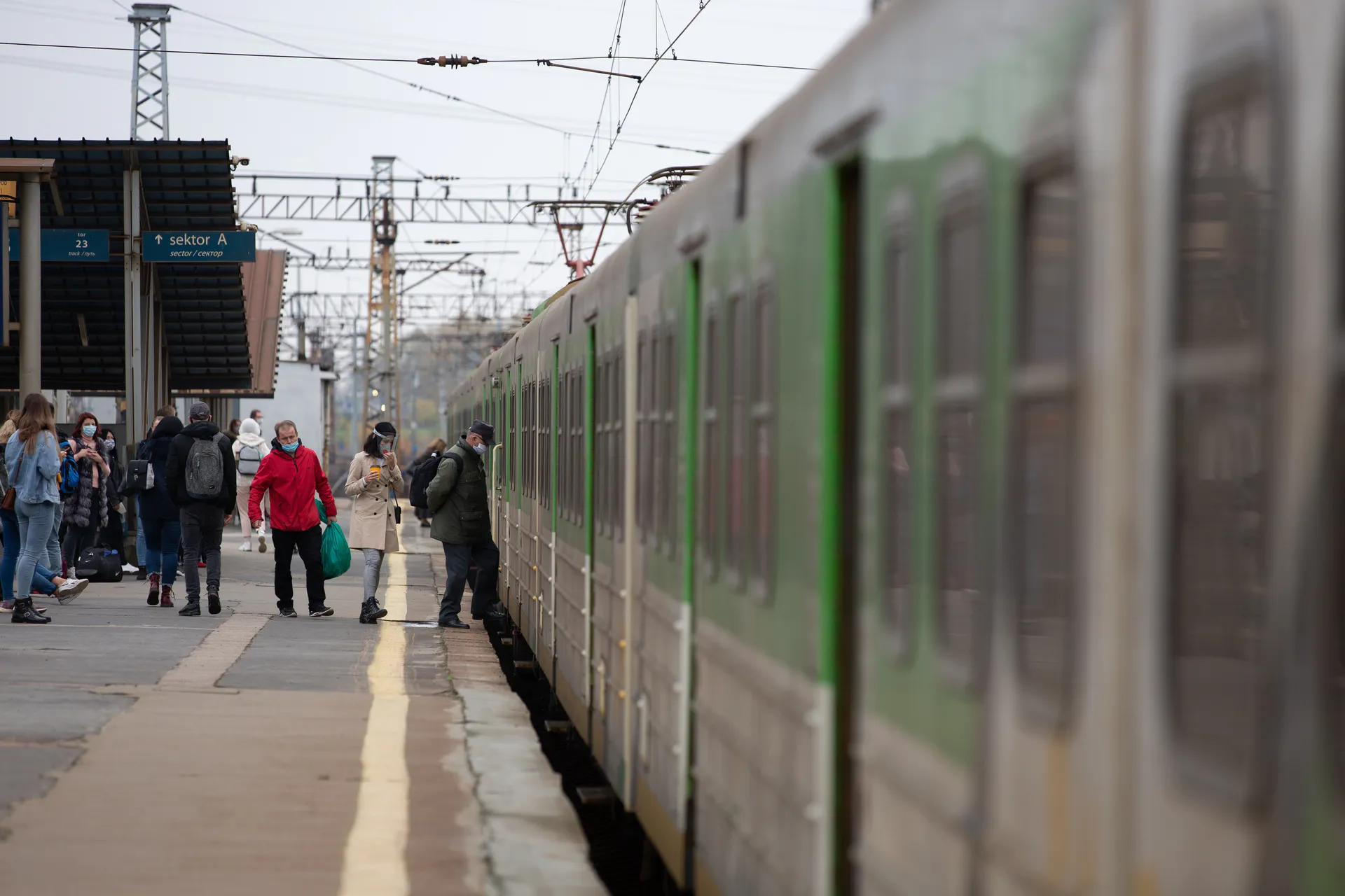 Konduktor PKP rozmawiający z pasażerem używającym e-papierosa w pociągu, być może wręczający mandat.