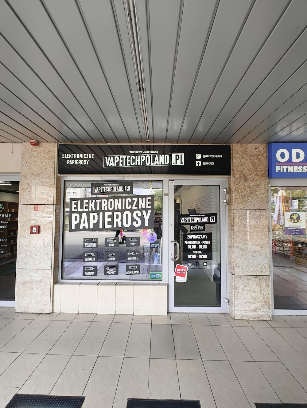 Zdjęcie stylowego, nowoczesnego vape shopu w Krakowie, z widokiem na charakterystyczne kamienice w tle i ikoną lokalizacji.