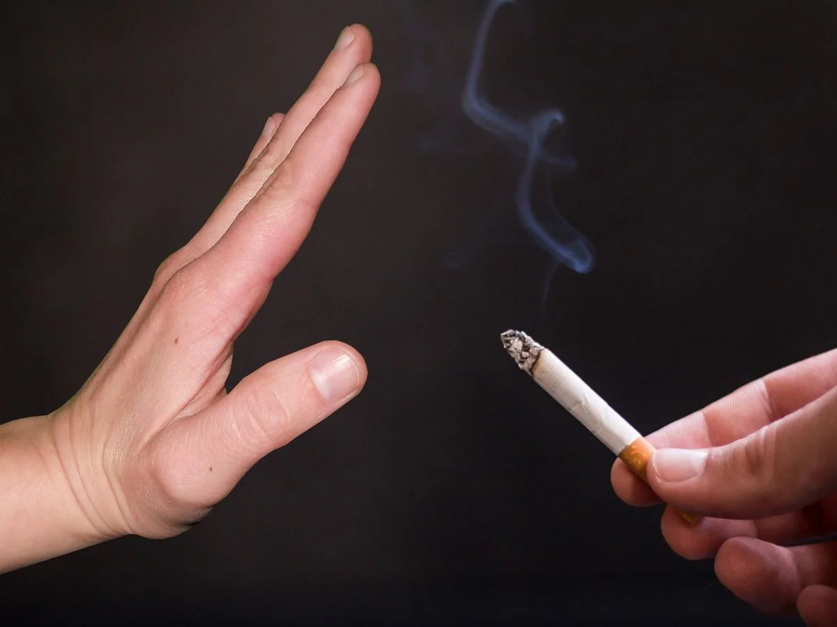 Uzależnienie behawioralne palenie, odruch ręka usta papieros, nawyk palenia, osoba z e-papierosem w dłoni - Palenie papierosów a utrata słuchu - aparaty-sluchowe.info